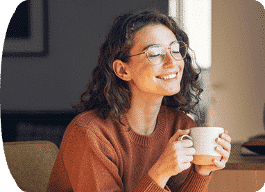 woman smiling while holding a cup